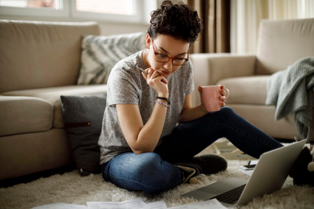 person sitting on floor looking at documents