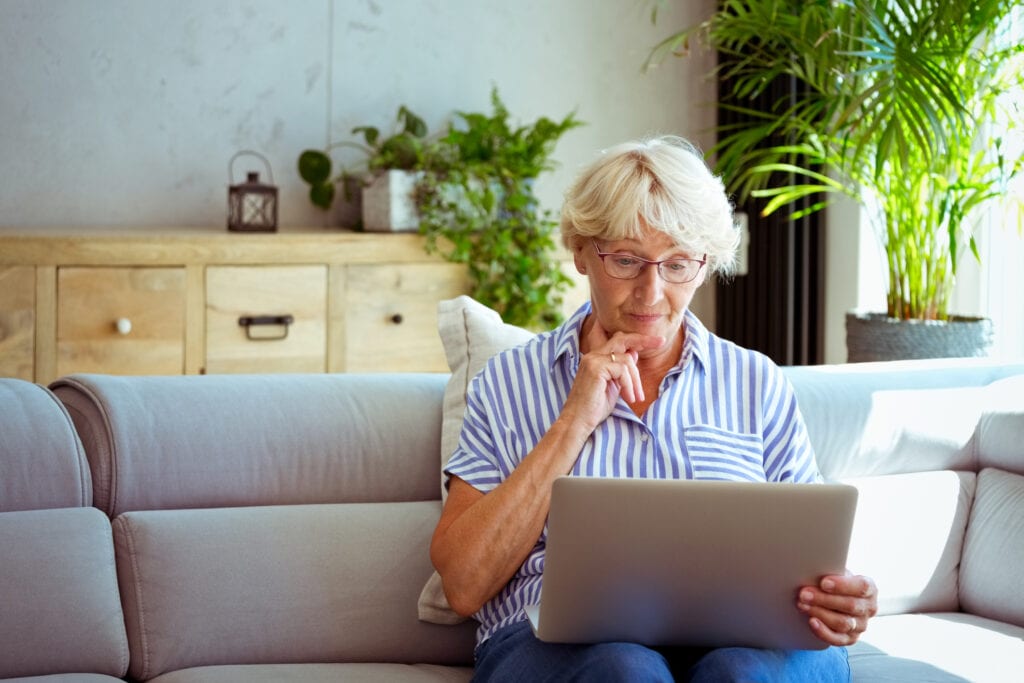 senior woman holding laptop gettyimages