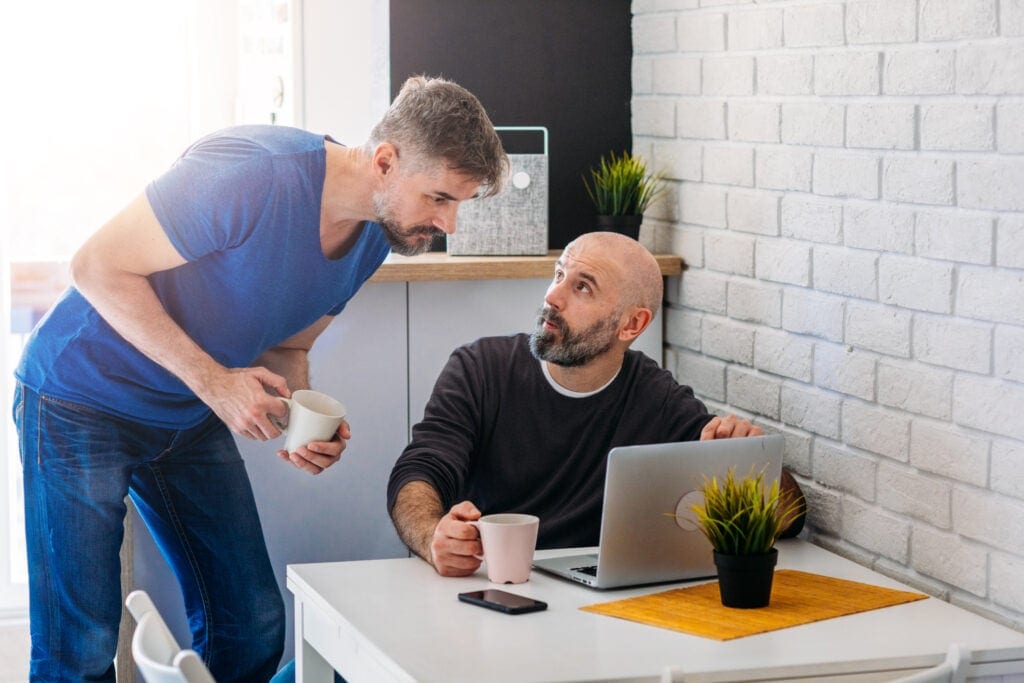 two people discussing something on laptop screen