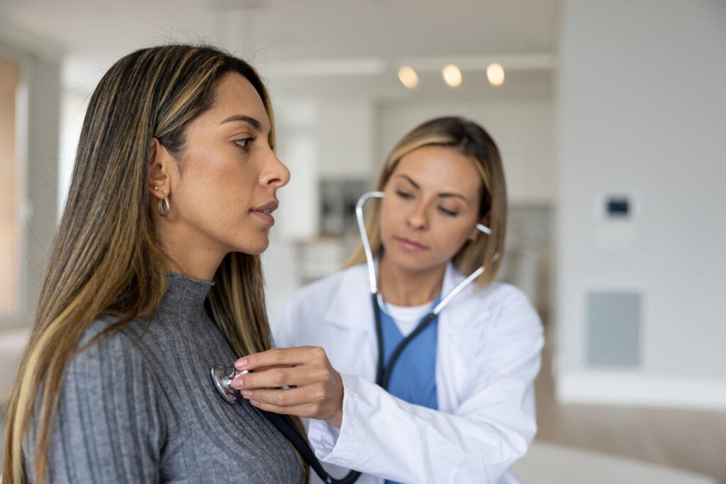 a doctor placing a stethoscope on a persons chest gettyimages