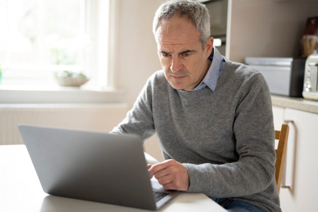 a person with a serious expression at a laptop gettyimages