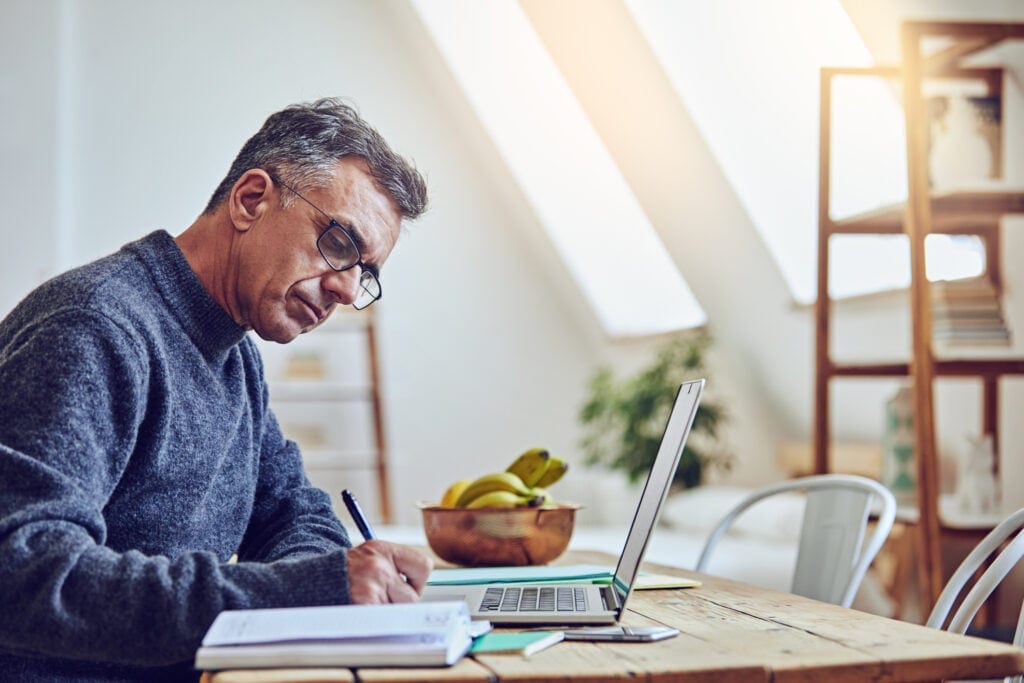 older man at laptop taking notes gettyimages
