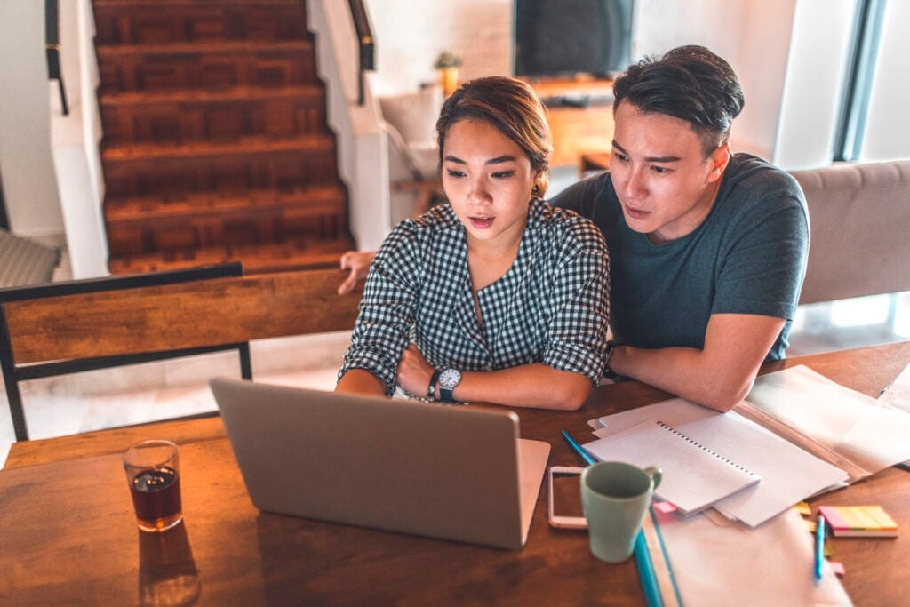 serious couple looking at laptop and discussing finances