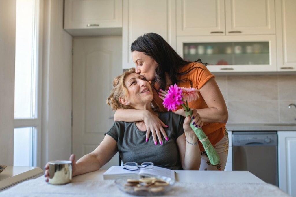 Daughter gives flowers and a hug to mother vm.width .jpg