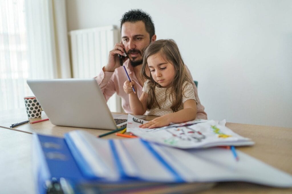 Father using laptop while on cell phone with .width rmjZiis