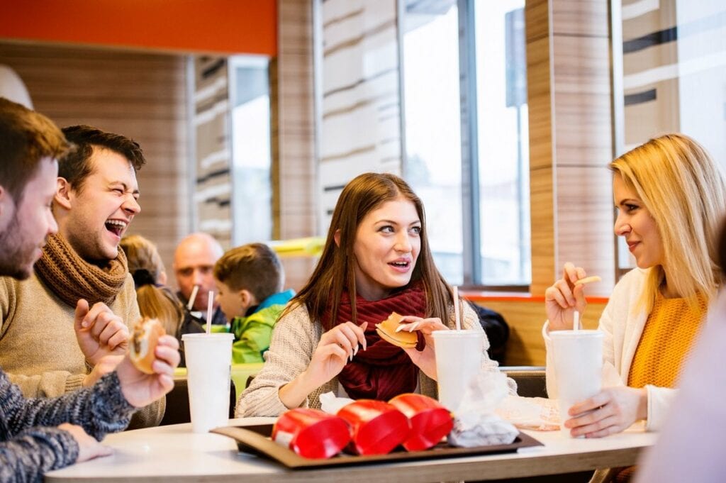 Group of friends eating fast food burgers and.width .jpg