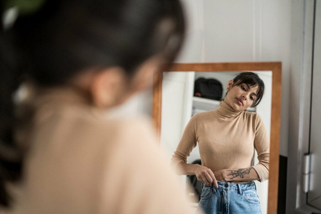 Person trying on clothing in mirror. EambWvL.width