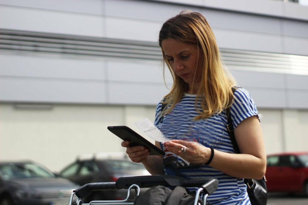 Woman in grocery store parking lot examining .width TGwgWbC