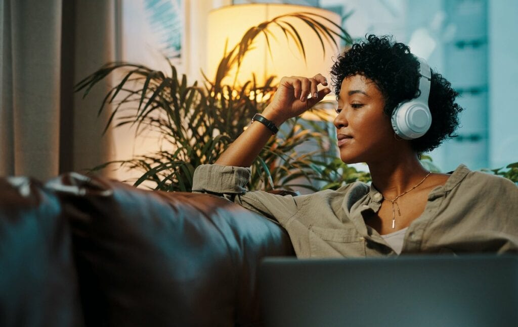 Woman listening to music through headphones. .width