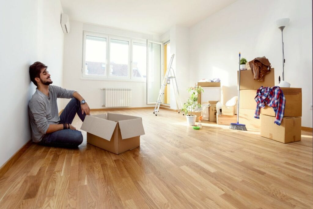 Young man empty apartment boxes imMTFem.width
