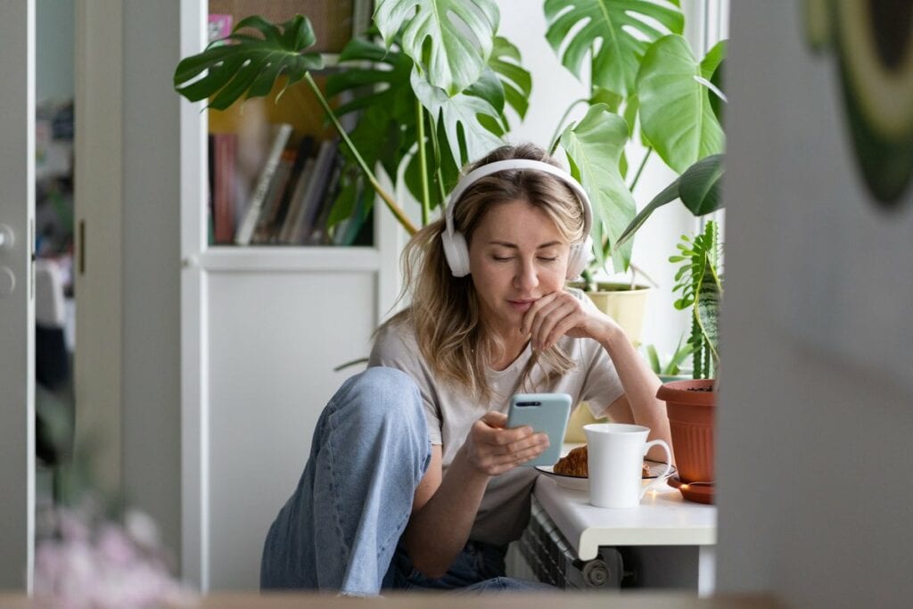 Young woman listening to podcast on her headp.width pSMxhS