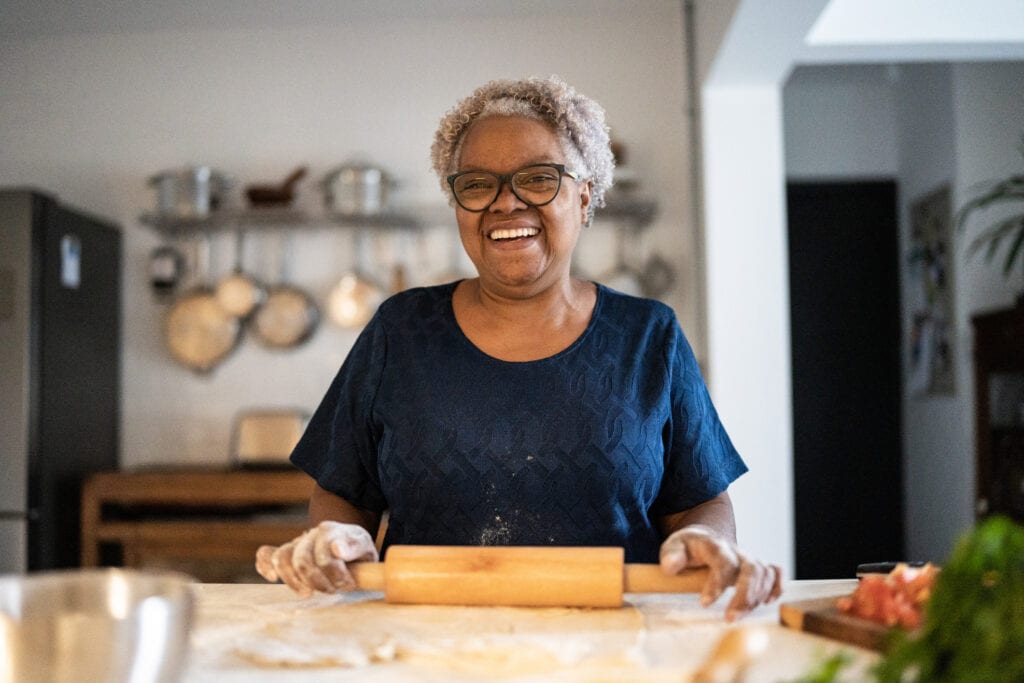 senior woman baking a smiling person holding a rolling pin gettyimages
