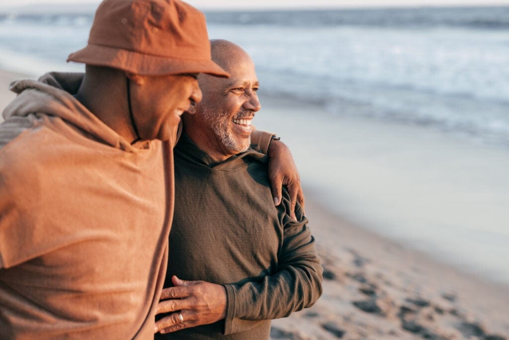 two people smiling hugging on the beach