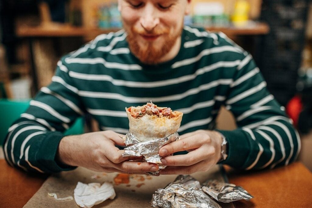 Man enjoying a burrito. JiUnfG.width .jpg