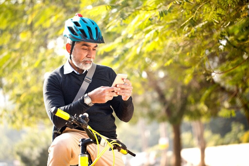 Man looking at his cell phone while riding hi.width TIdVD.jpg