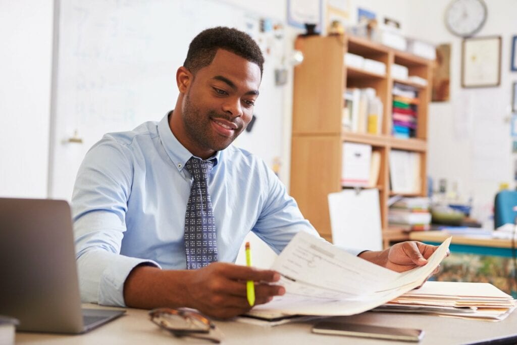 Man reading paperwork at desk UyTBhM.width .jpg