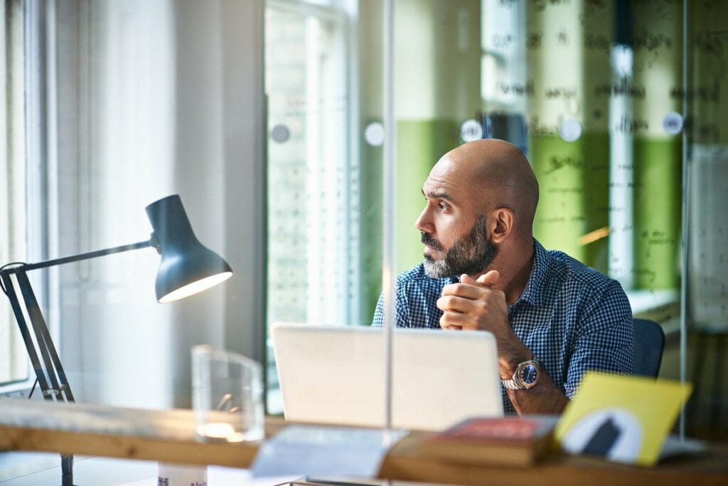 Mature man at desk looking off in thought ZmW.width .jpg
