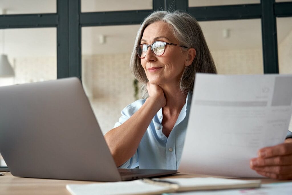 Mature woman working from laptop with documen.width ZiqNtKV.jpg