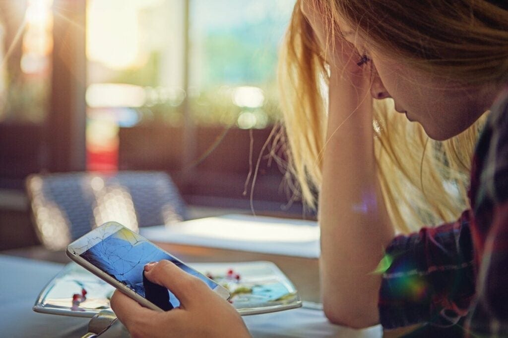 Woman holding smashed cell phone WAun.width .jpg