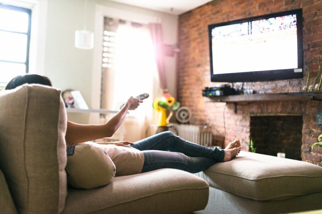 Woman lounging on her sofa watching tv hUjj.width .jpg