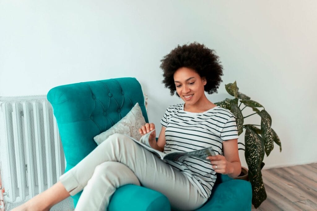 Woman reading magazine in a chair. XUgBQV.width .jpg