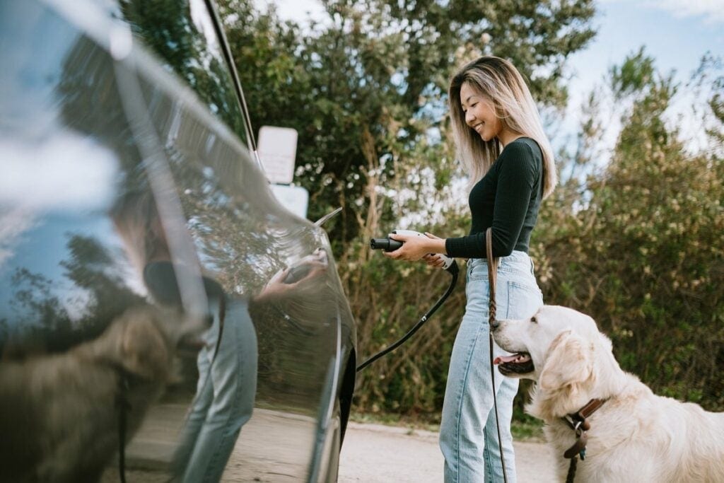 Woman with dog about to charge her electric c.width gkkvUm.jpg