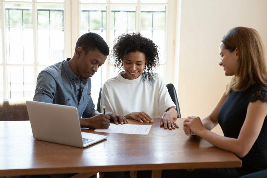Young couple signing papers with an agent aq.width .jpg