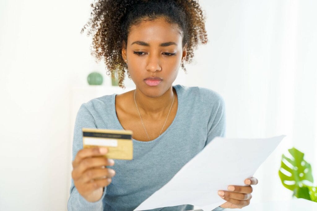 Young woman looking at credit card uQDfnW.width .jpg