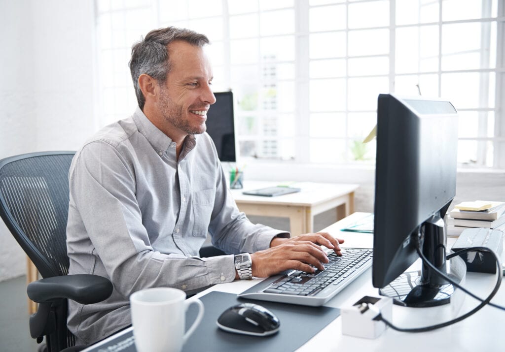 a smiling person at a computer gettyimages .jpg
