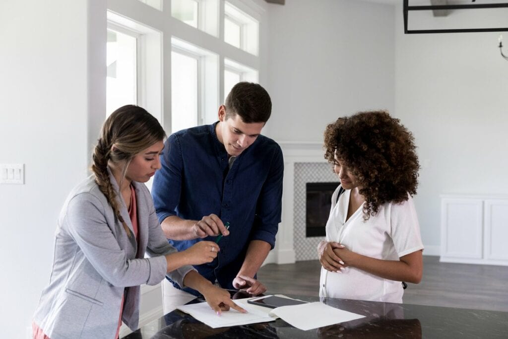 couple with realtor signing papers.width .jpg