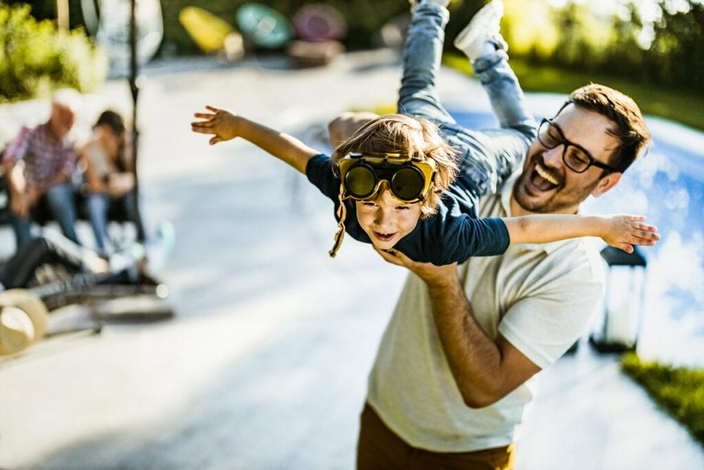 dad holding son in air FBKHHl.width .jpg