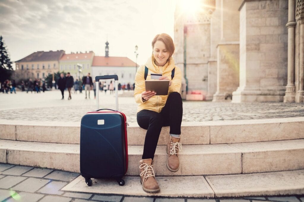 female traveler with suitcase tablet and cred.width sQbWMG.jpg