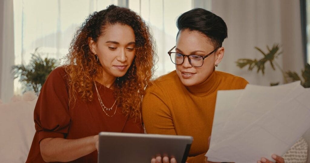 two people looking at tablet and paperwork aL.width .jpg