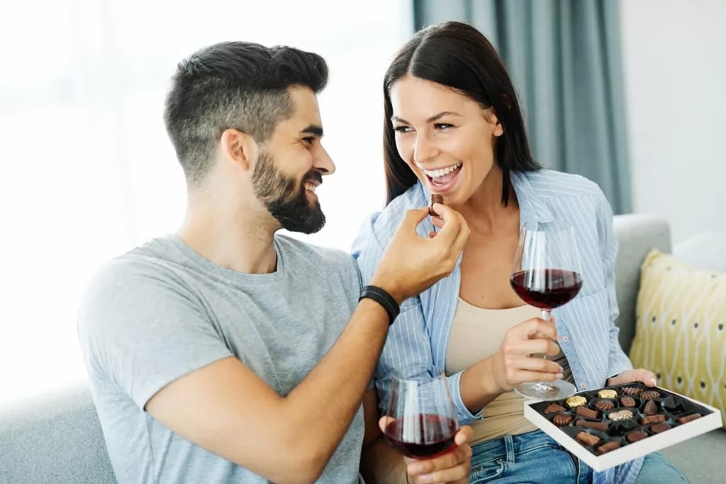 Couple eating chocolates and drinking wine to.width .jpg