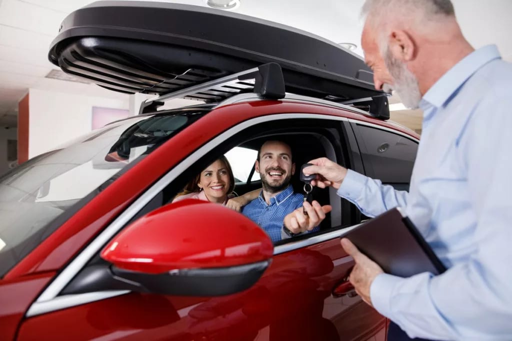 Couple receiving a new car keys from car sale.width PKhkAs.jpg