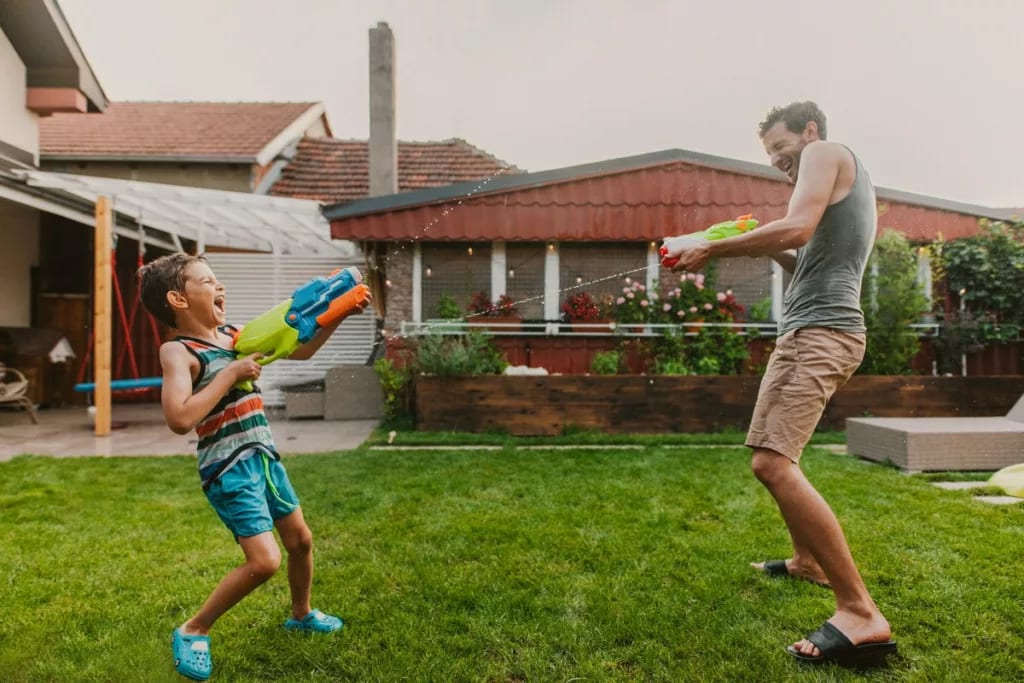Man and child play with squirt guns in homes .width qPwAKO.jpg