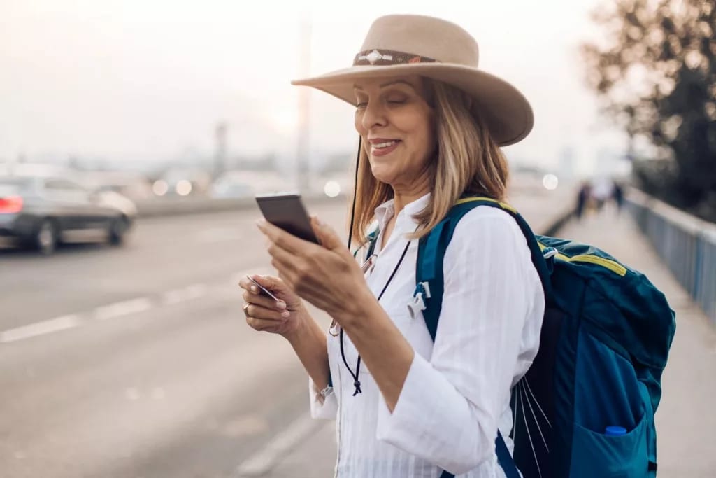 Mature woman holding her phone and a credit c.width UAbKy.jpg