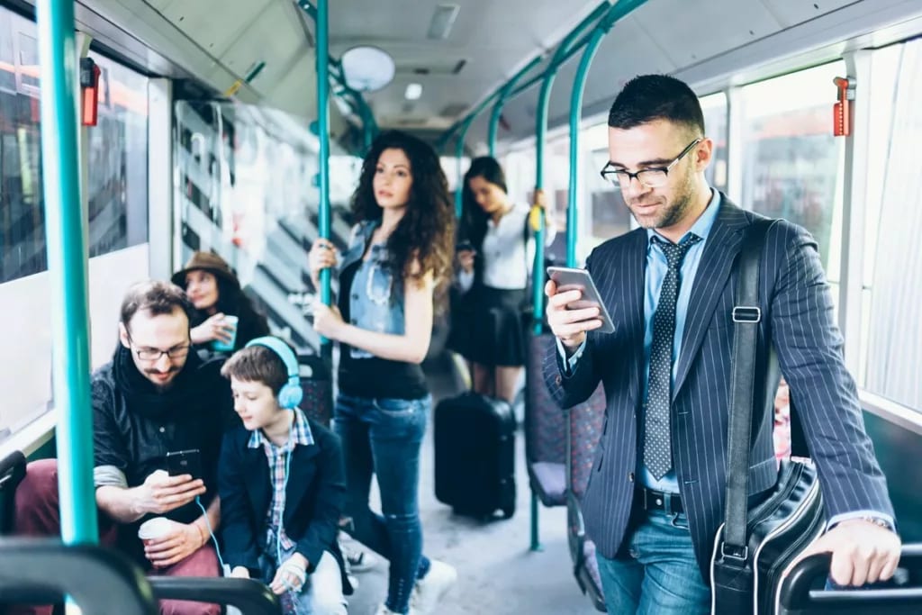 People on a bus with several using their cell.width EBrObLs.jpg