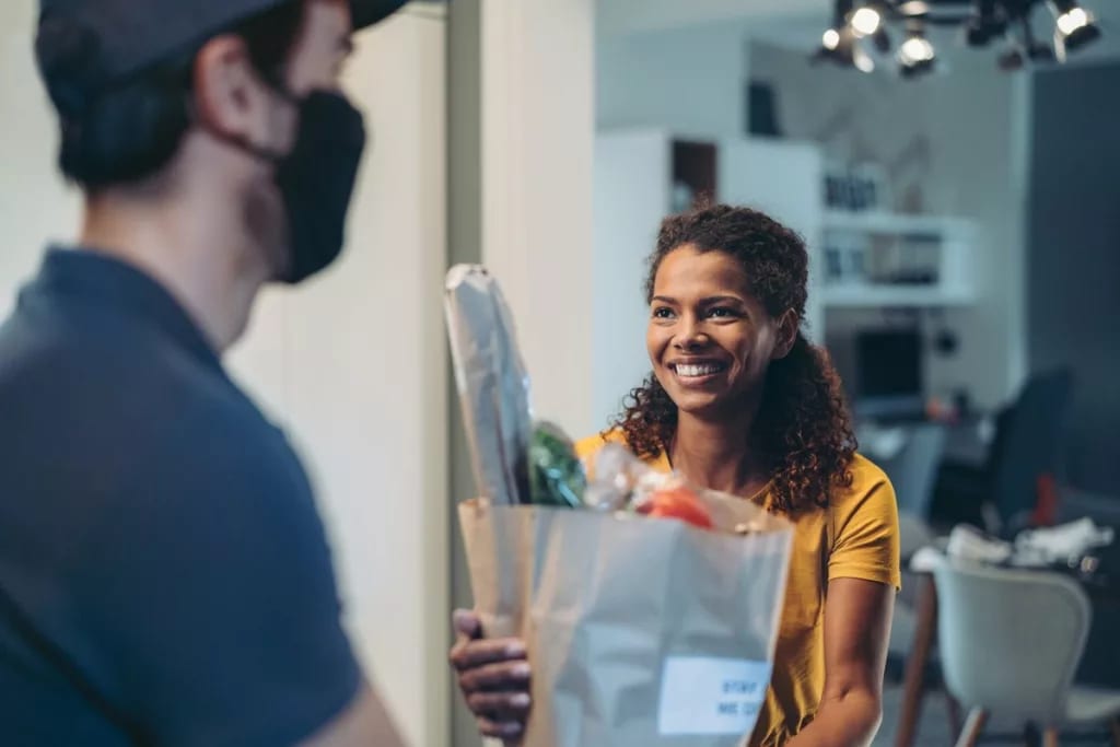 Woman accepting a delivery of groceries. EZB.width .jpg