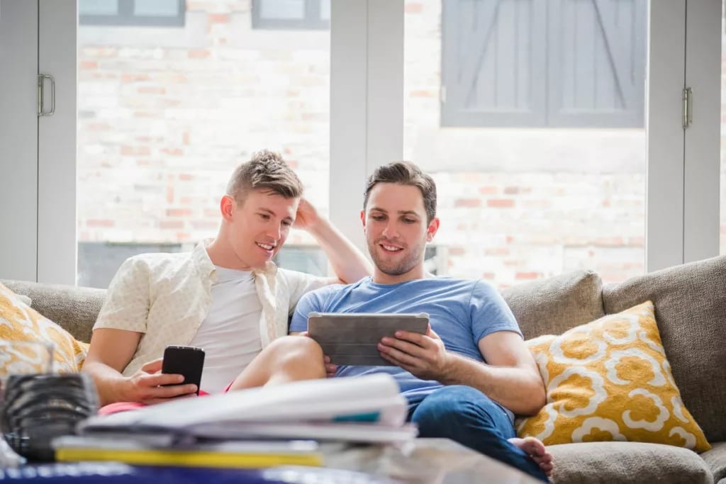 Young couple sit on sofa and look at tablet .width .jpg