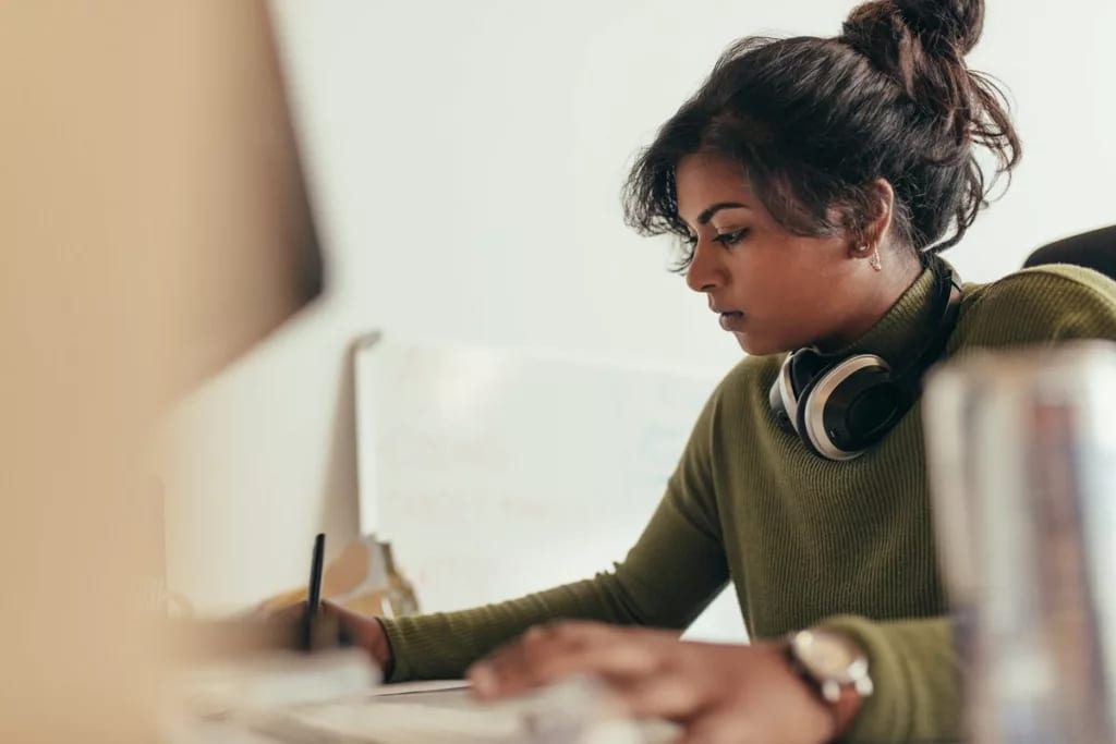 Young woman writing with headphones rJQSmvR.width .jpg