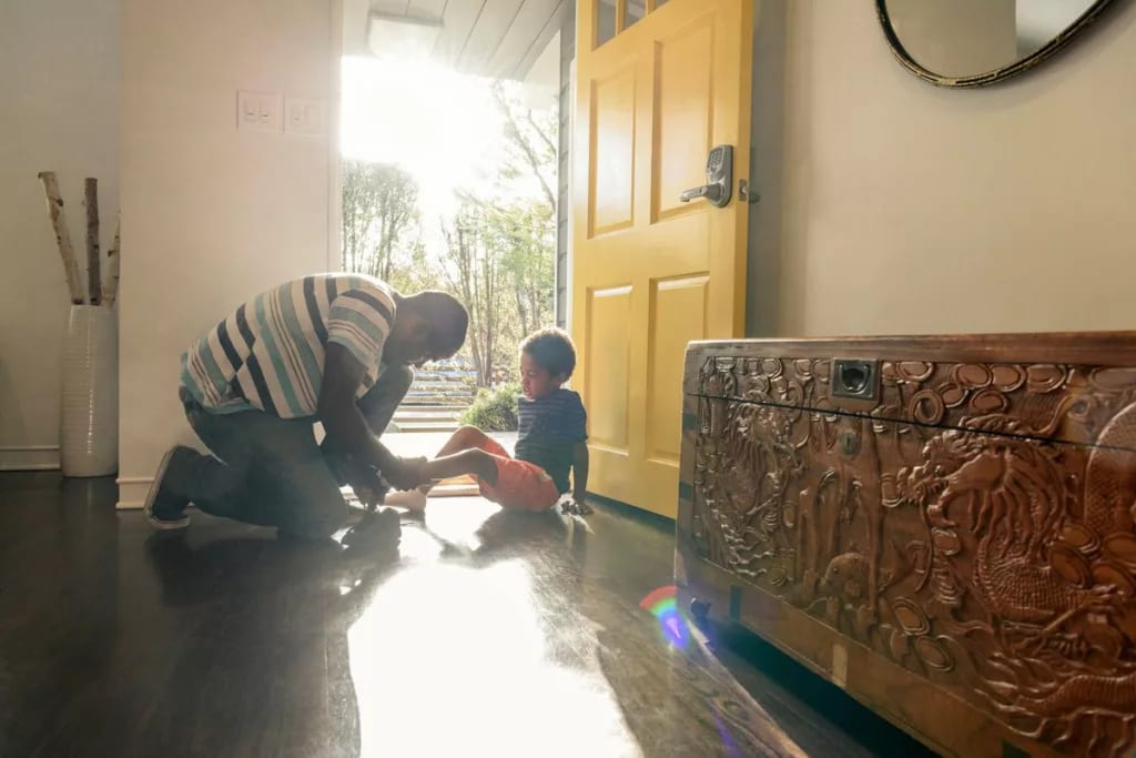 person putting on childs shoes at front door .width hxnClq.jpg