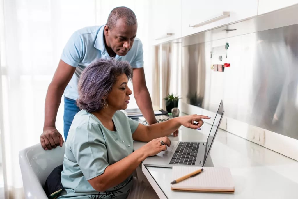 two people at a desk using a laptop.jpg
