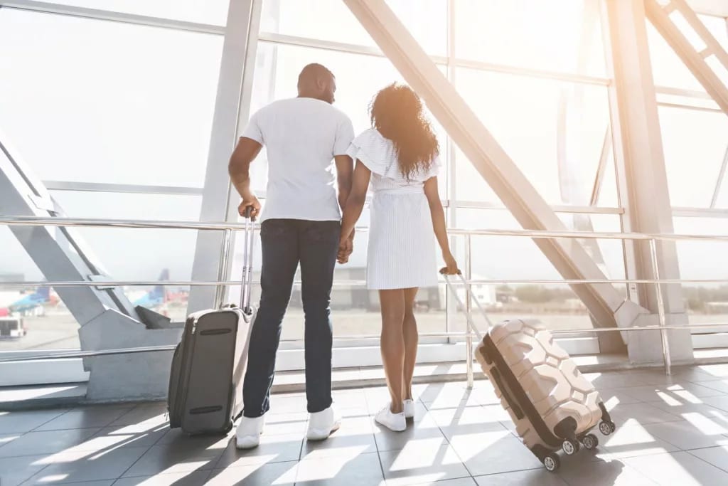 two people with suitcases holding hands hNDS.width .jpg