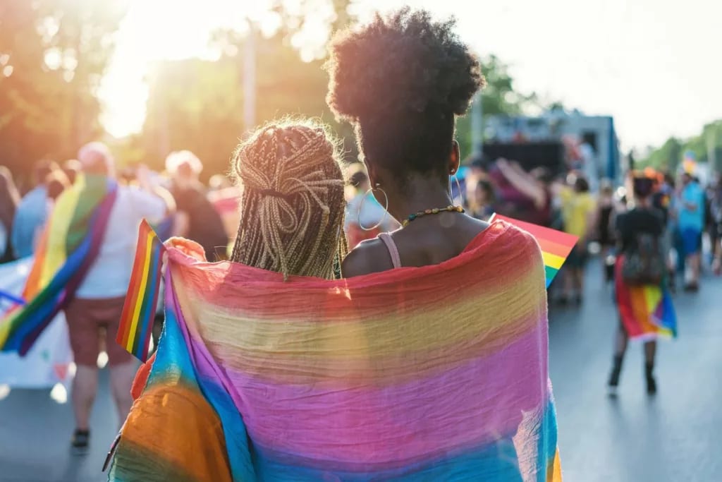 two women in rainbow flag at parade.width .jpg