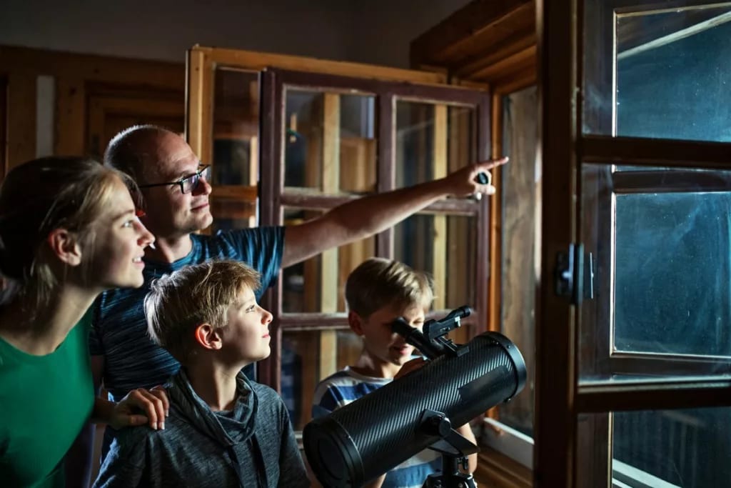 Fmaily looking at the night sky through a tel.width TypJxr.jpg