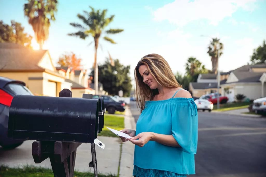 Woman checking mailbox in neighborhood with p.width WPxG.jpg