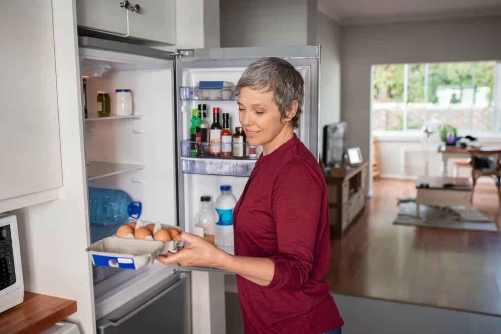Woman opening refrigerator ymOwHf.width .jpg