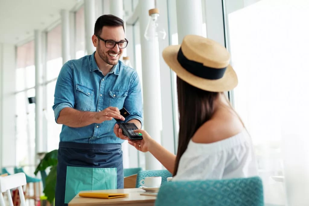 Woman paying waiter credit card KqTSHc.width .jpg