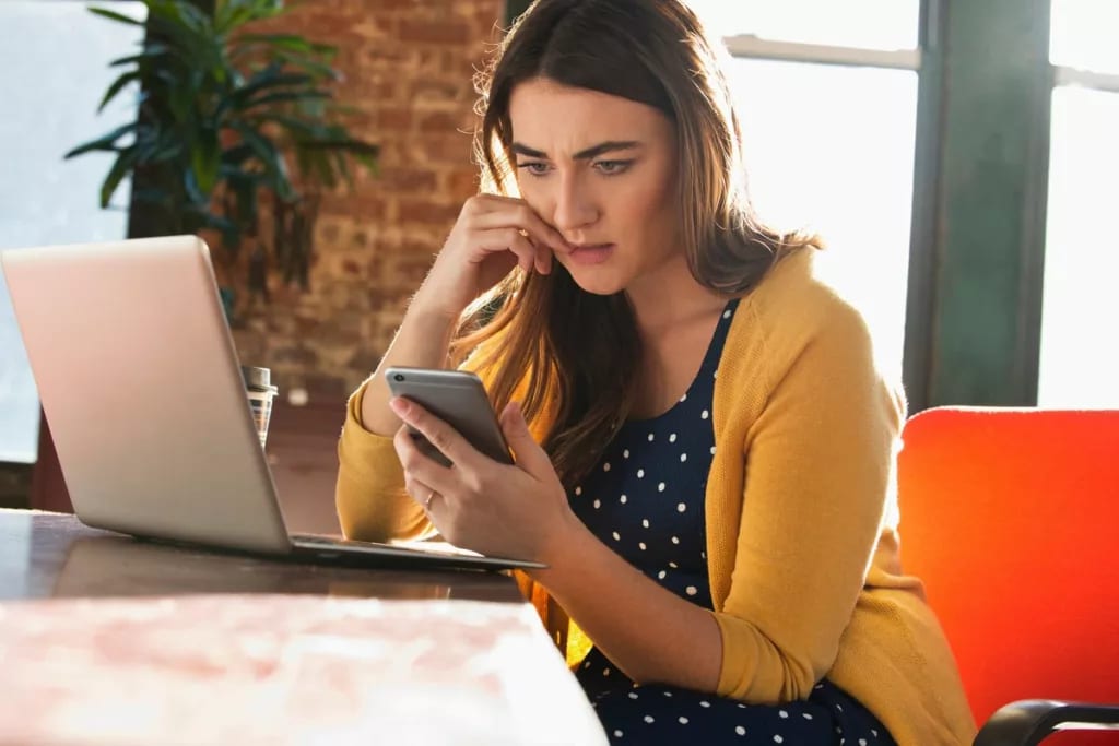 Woman using cell phone with concerned look on.width UczVhr.jpg